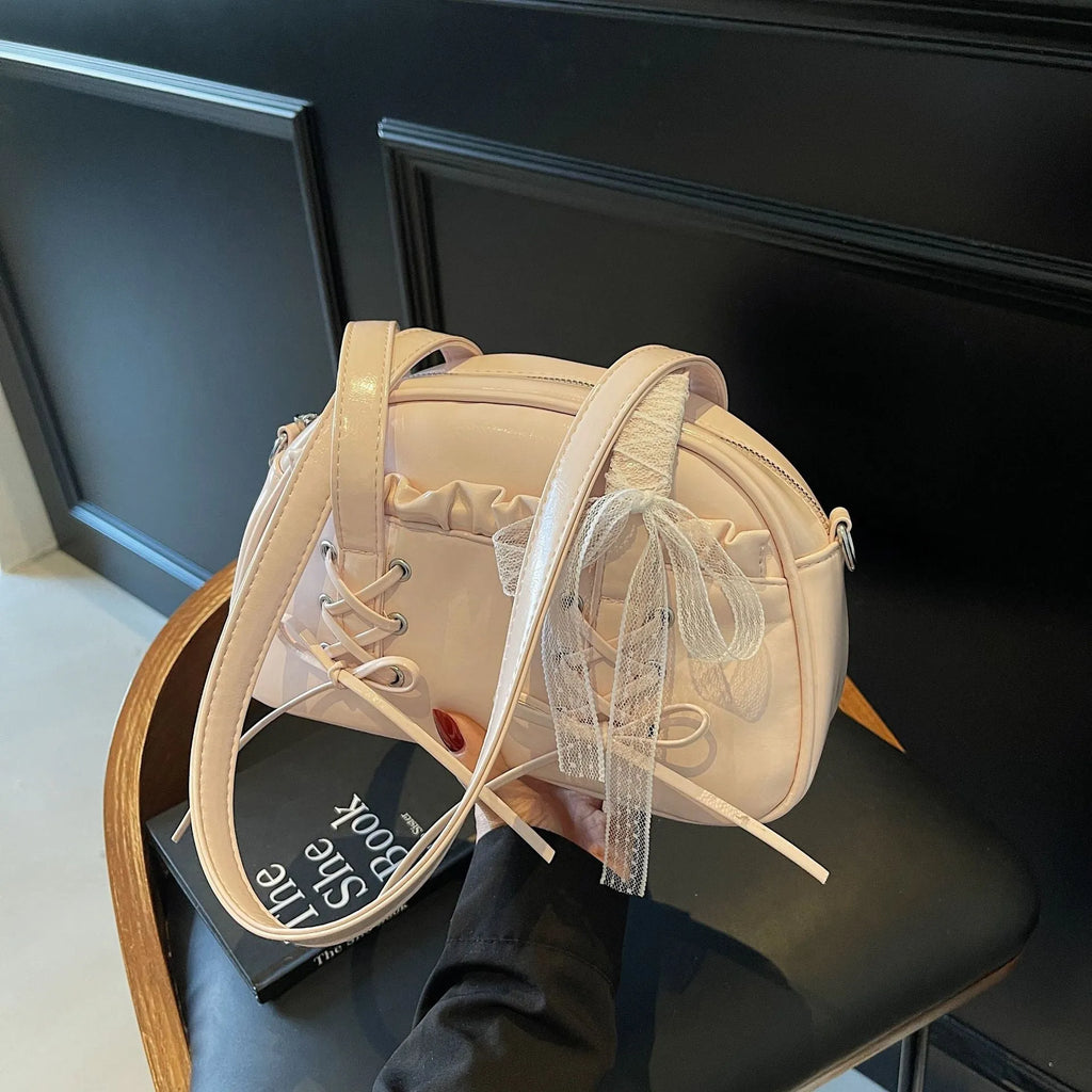 Women's milky white PU shoulder bag with bandage bow and stitching detail, showing internal phone pocket.