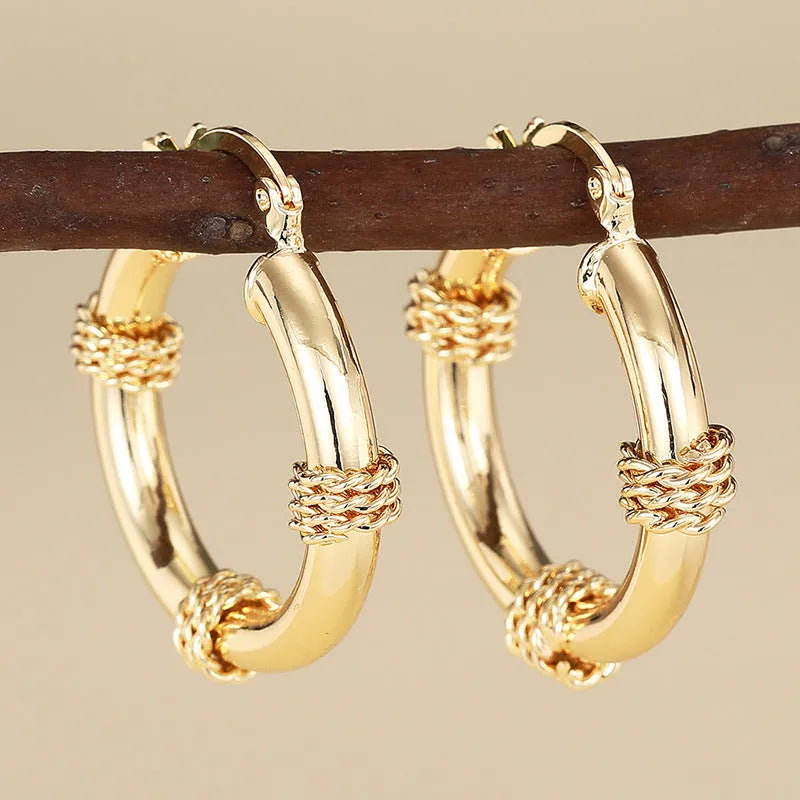 Geometric copper ear clips for women in a golden colour with clean line detailing on a white background.
