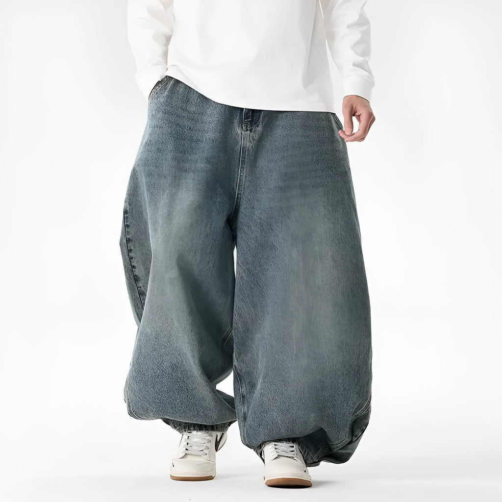 Men's loose fit light blue denim jeans with a straight leg and low waist, laid flat.