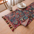 Dark blue striped floral jacquard table runner laid flat on a wooden dining table.