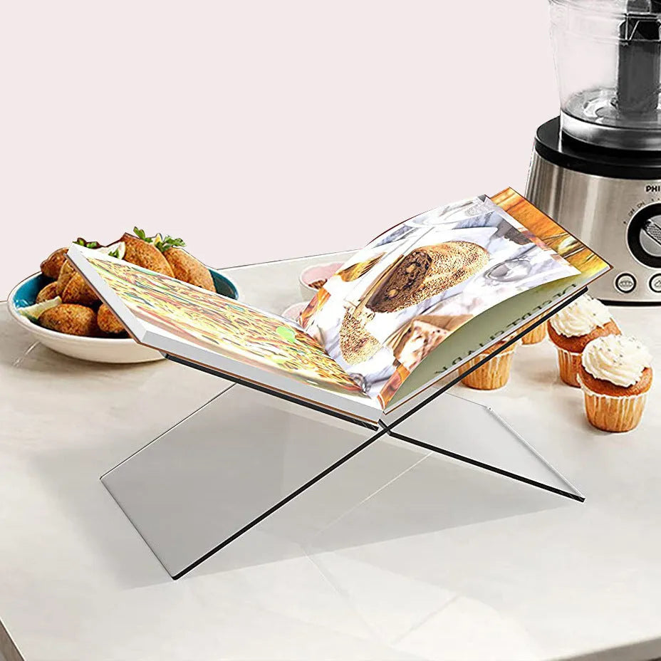 Transparent acrylic X-shaped book display rack holding books upright on desktop