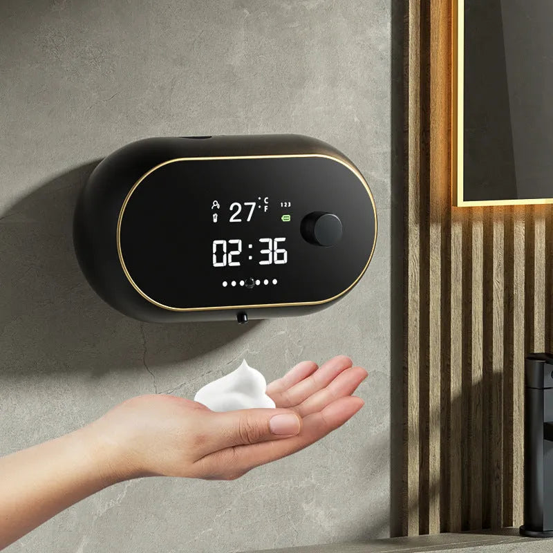 White automatic wall-mounted soap dispenser with USB cable on a bathroom wall