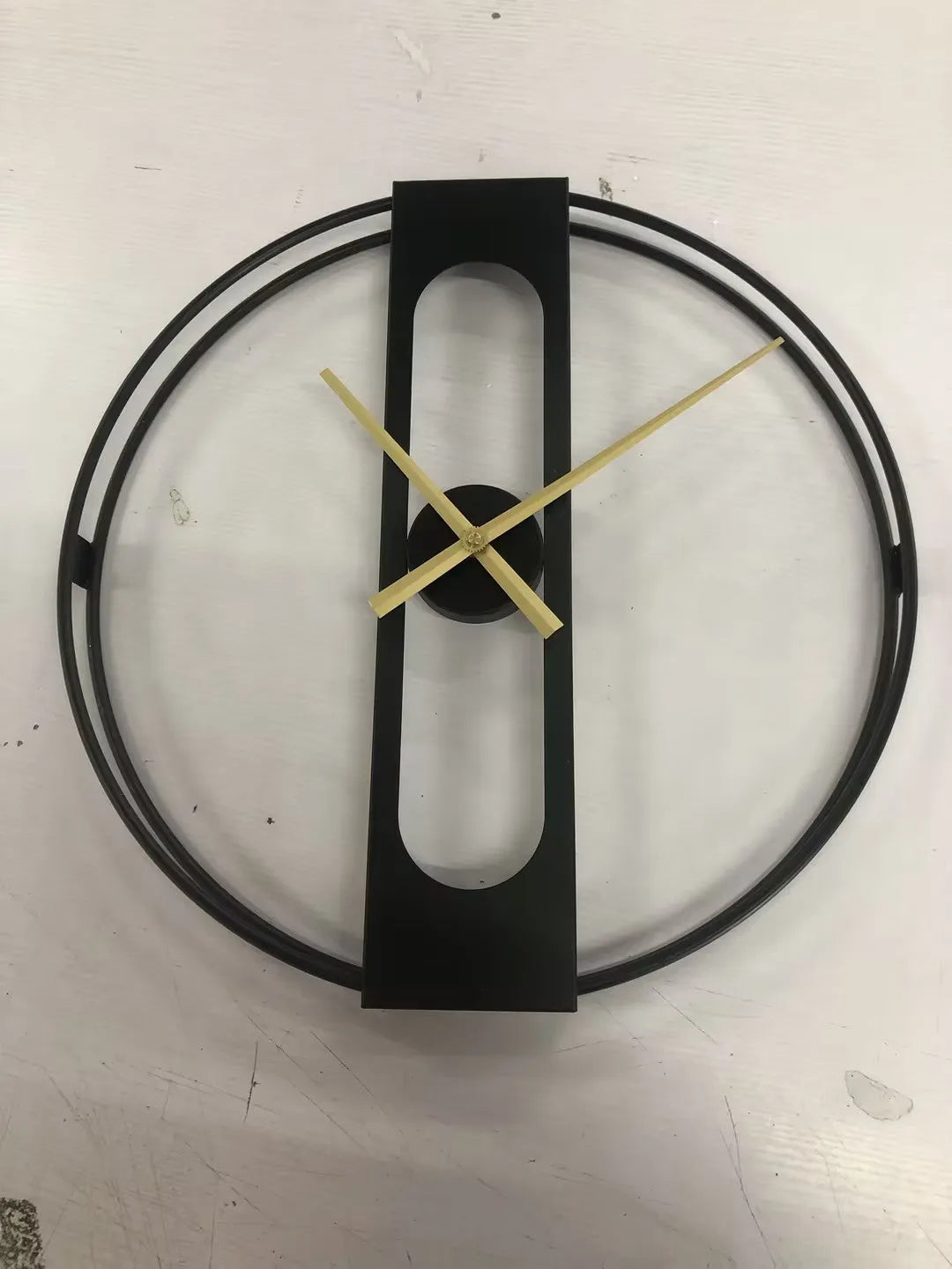 Round metal wall clock with 50cm diameter face in black or gold colour on white wall