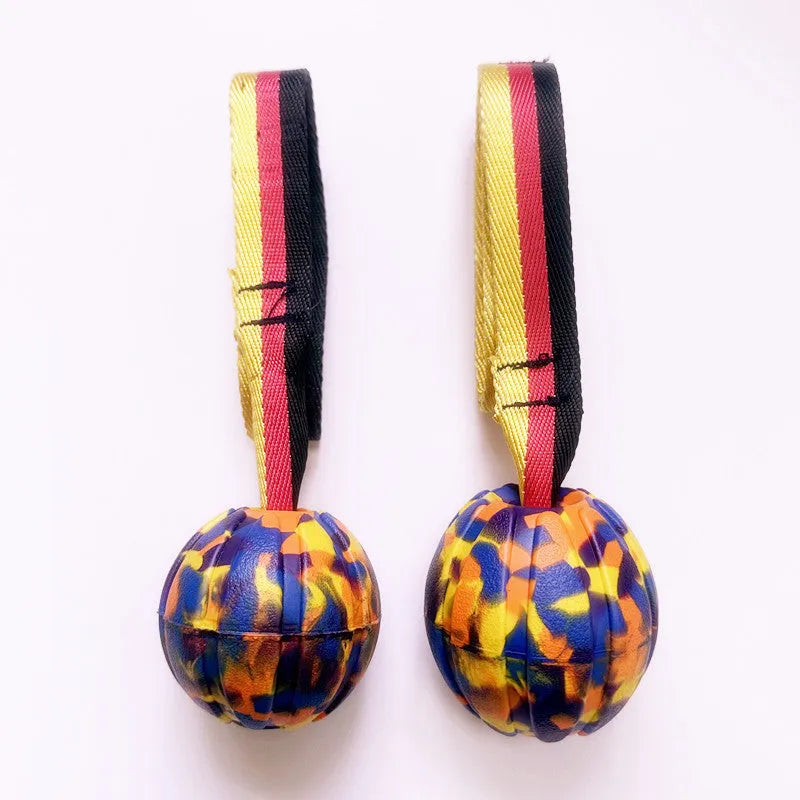 Yellow and camouflage coloured EVA floating dog chew balls in three different sizes on a blue background.