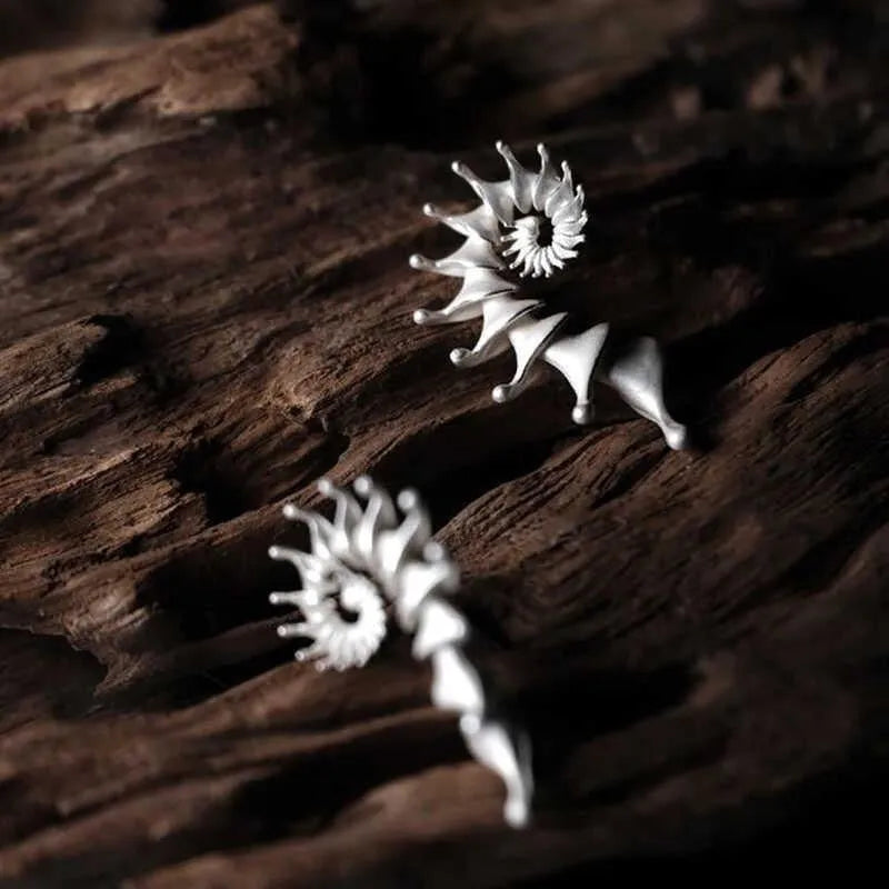 A pair of matte finish alloy conch stud earrings with a three-dimensional, irregular shape.
