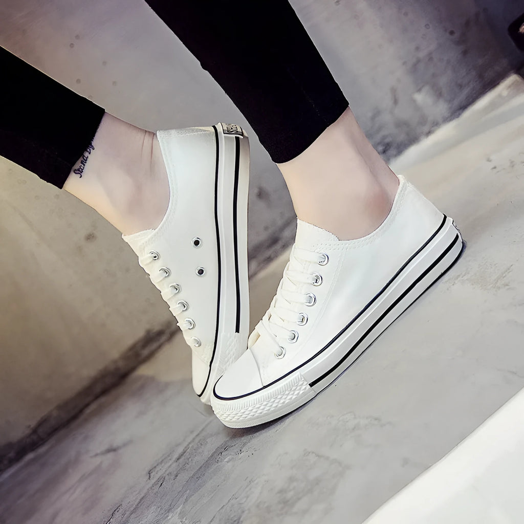 Women's solid-colour canvas lace-up trainers on a white background, showing the casual design and lace detail.