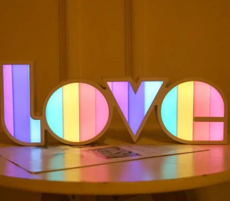 LED LOVE Light with colourful rainbow lampshade on a desk