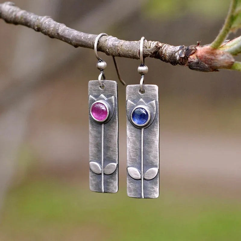 A pair of antique finish red sapphire earrings with a geometric ellipse design in a retro style.