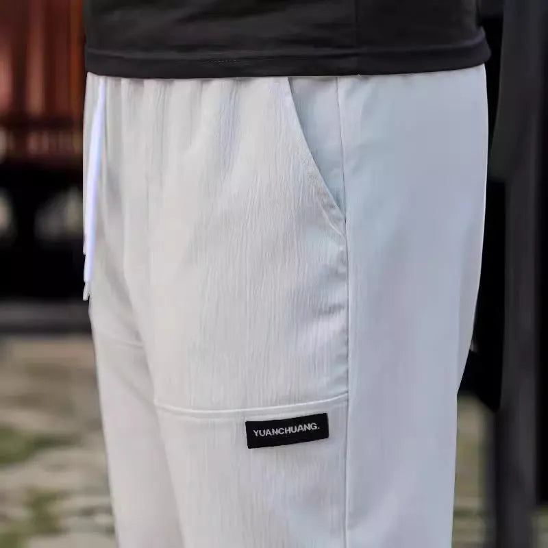 Men's polyester trousers in light grey colour shown flat