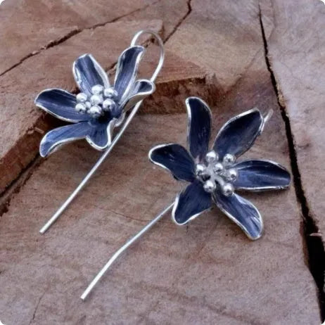Purple floral alloy drop earrings with retro design on white background