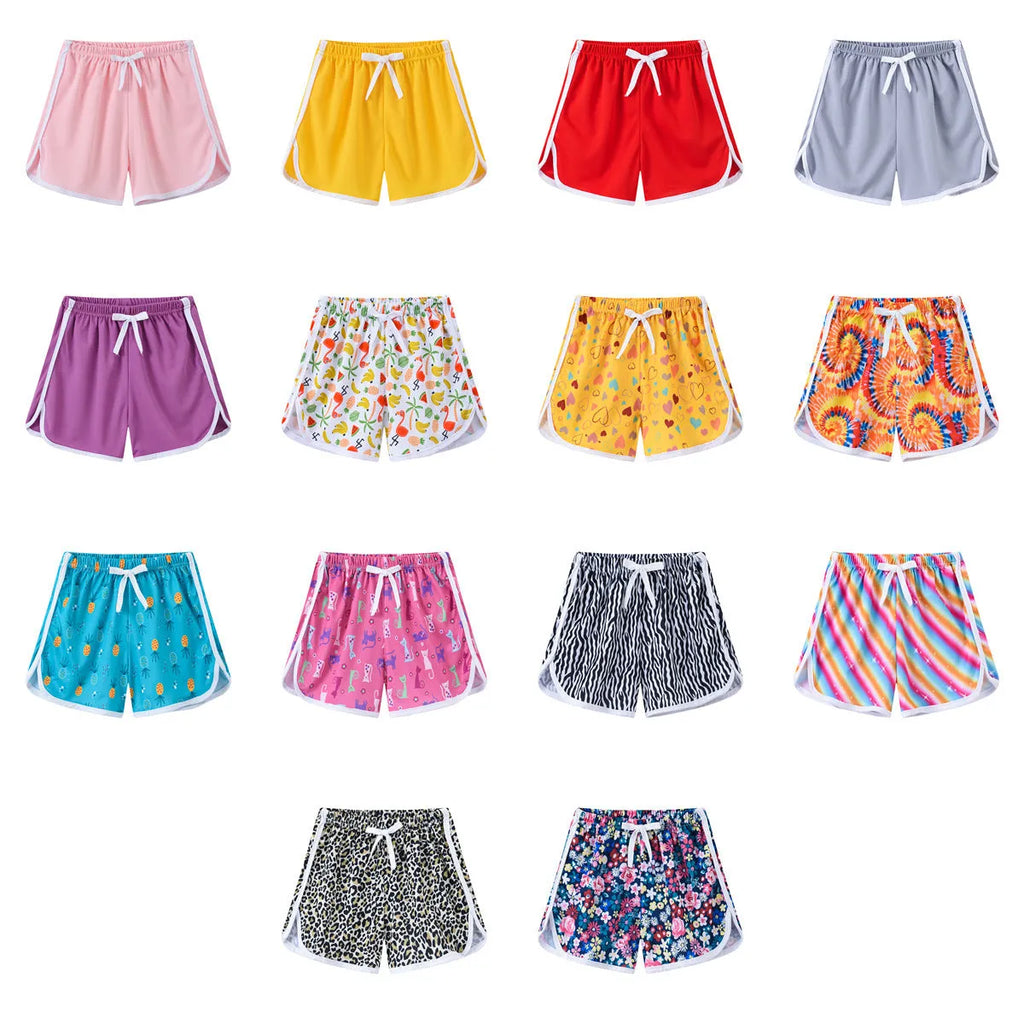 Children's polyester beach shorts in multiple colour and pattern options including solids, stripes, and fruit prints