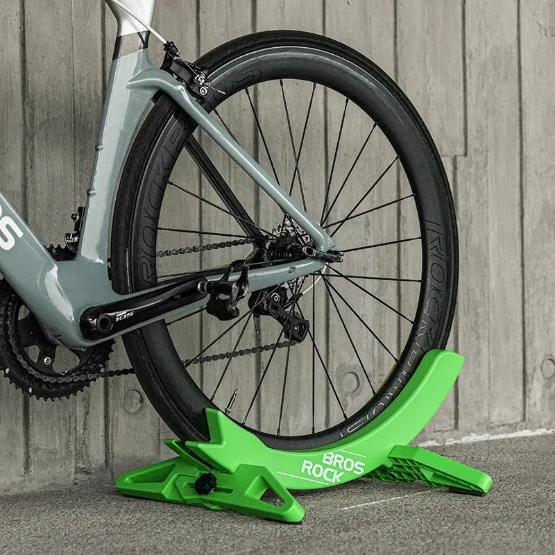Black or green ABS plastic bicycle parking rack holder mounted on wall with road bike