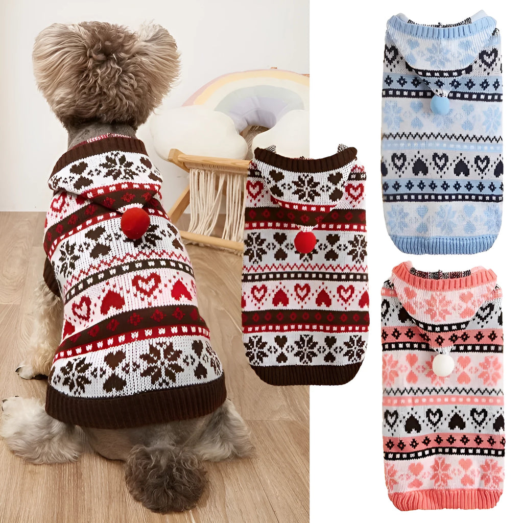 Pink knitted dog sweater with snowflake, heart, and camouflage stripe pattern on a small white dog.