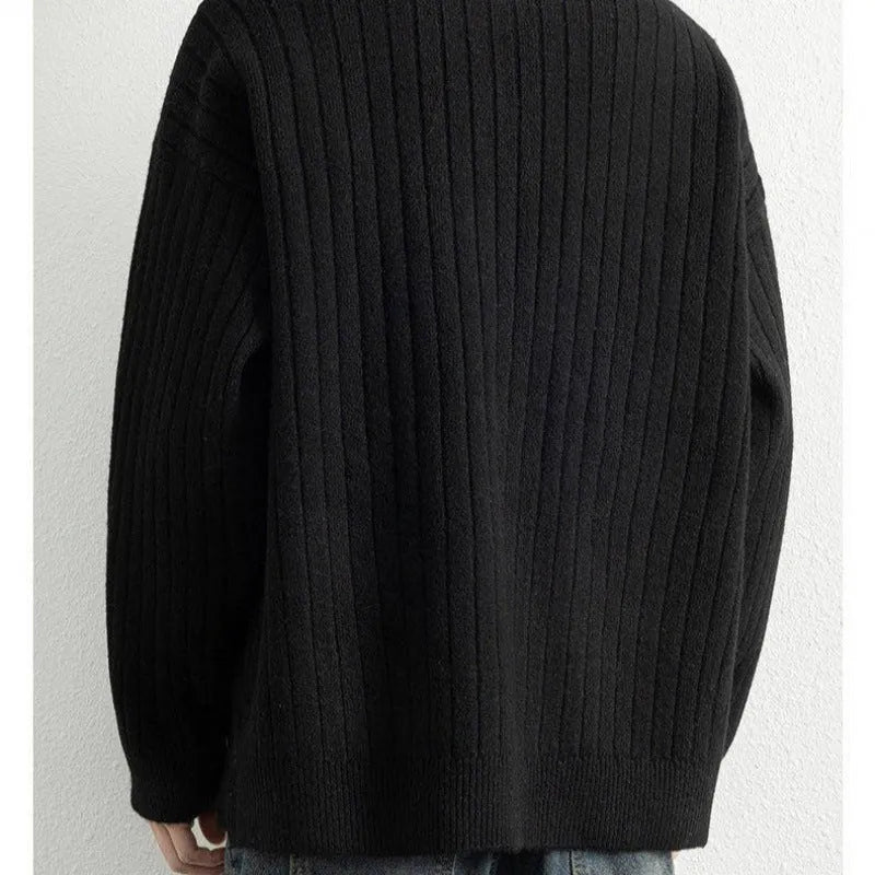 Man wearing a grey half zip loose fit textured knit sweater with long sleeves.