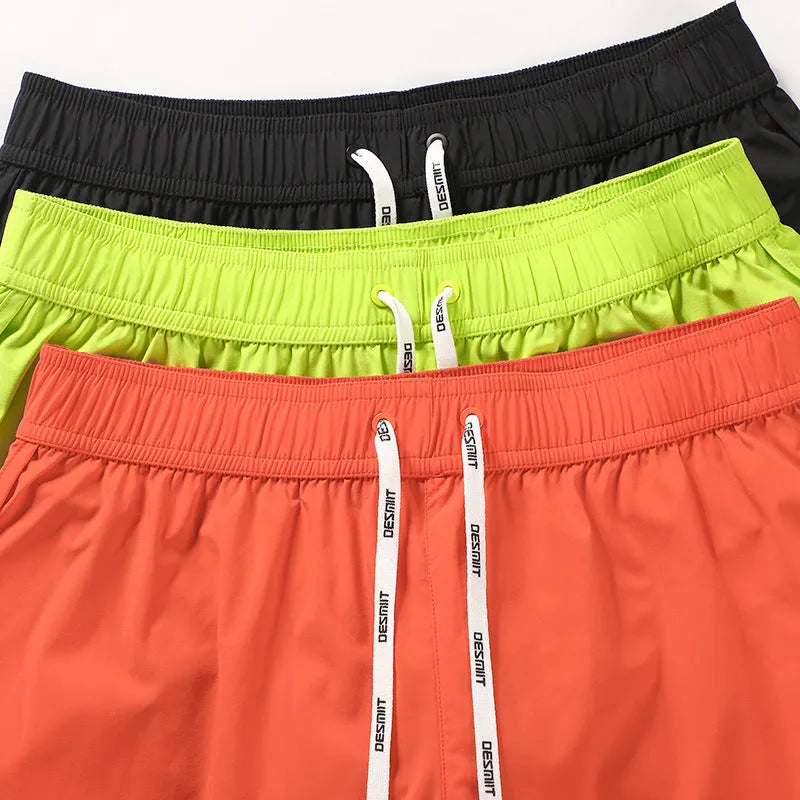 Men's elastic waist beach shorts in black, fluorescent green, or orange red colours for surfing and swimming