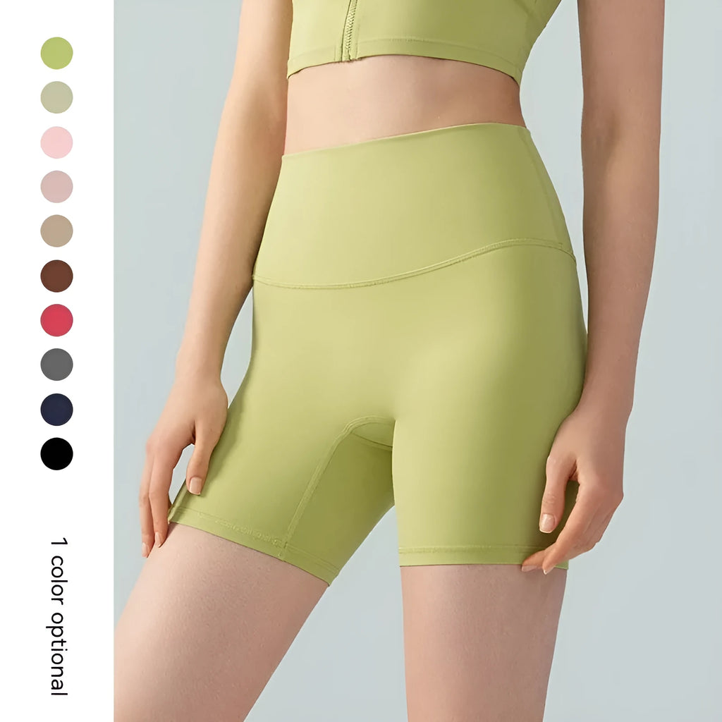 Woman wearing high-waisted leaf green yoga shorts with a four-point cycling pants design.