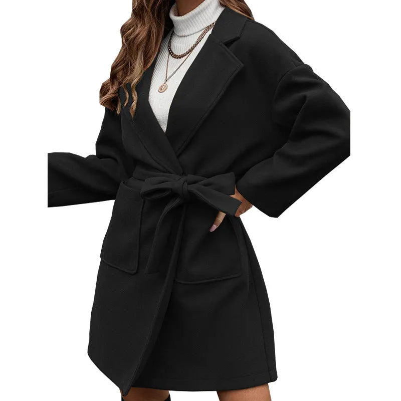 Long sleeve minimalist coat with belt and button closure in loose casual fit.