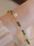 Natural green olivine stone bracelet with double layer Twin Bells of Ireland and Olive Branch design on an adjustable band.
