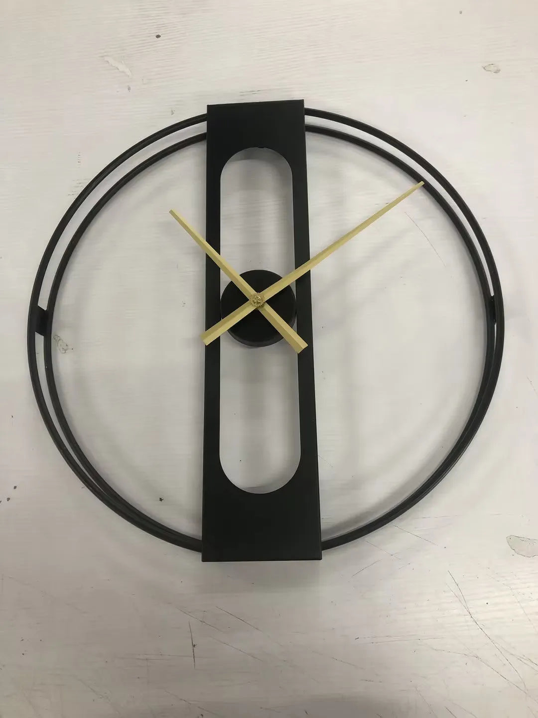 Round metal wall clock with 50cm diameter face in black or gold colour on white wall