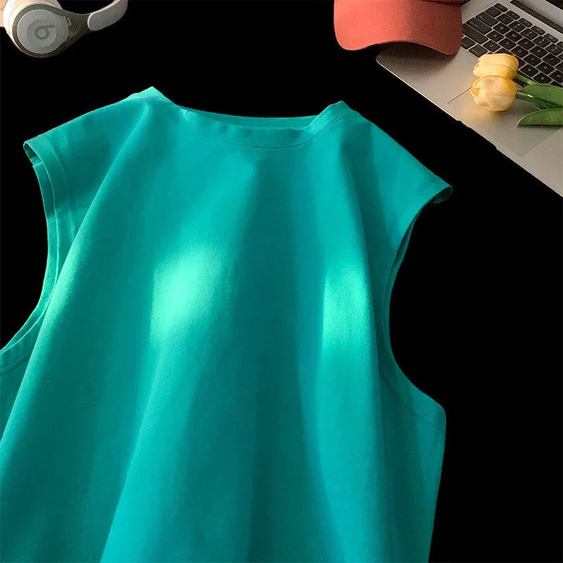 Men's loose fit solid colour cotton tank top on a hanger, shown in apricot colour.