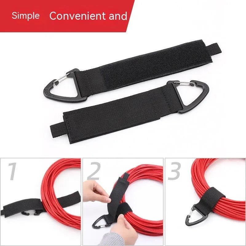 Black heavy gravity climbing storage strap with carabiner hook shown extended vertically