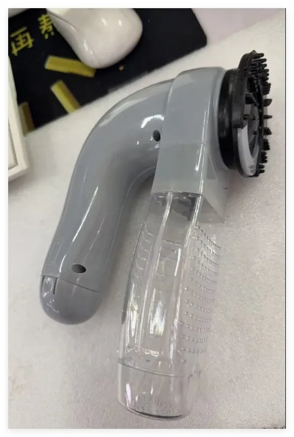 Grey portable electric pet hair vacuum cleaner with grooming brush.