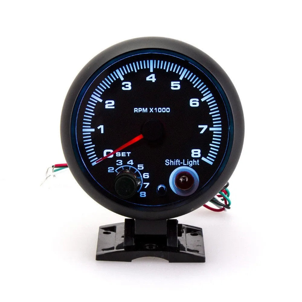 Black plastic automotive tachometer with blue indicator light for engine RPM measurement.