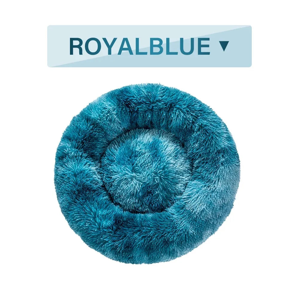 Fluffy donut-shaped dog bed in long plush material, shown in one of multiple available colours