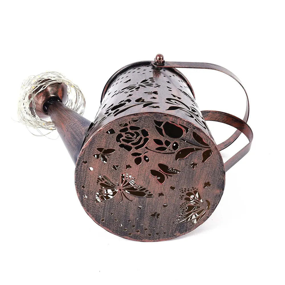 Solar-powered tapered butterfly pattern iron garden lamp emitting warm white light.