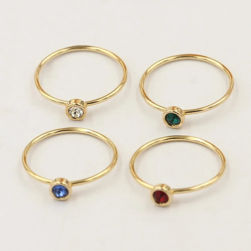 Copper knuckle ring with gold gild and coloured GF zircon stones on a finger.