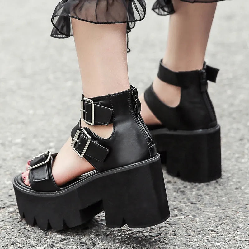 Black punk-style women's sandals with a chunky heel, thick platform sole, and back zipper.