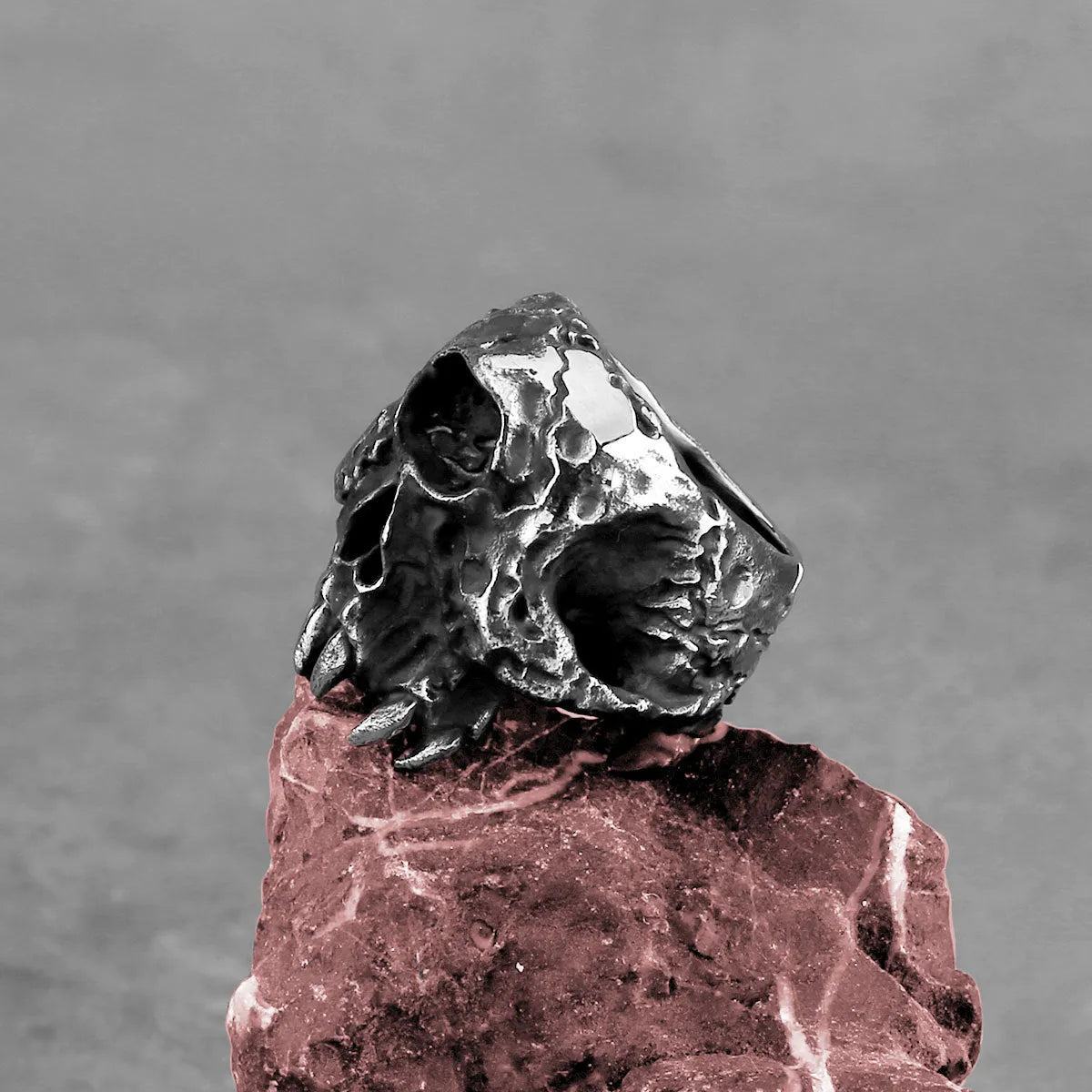 Alloy ring with a detailed one-eyed skull design on a finger, showing its metallic retro finish.