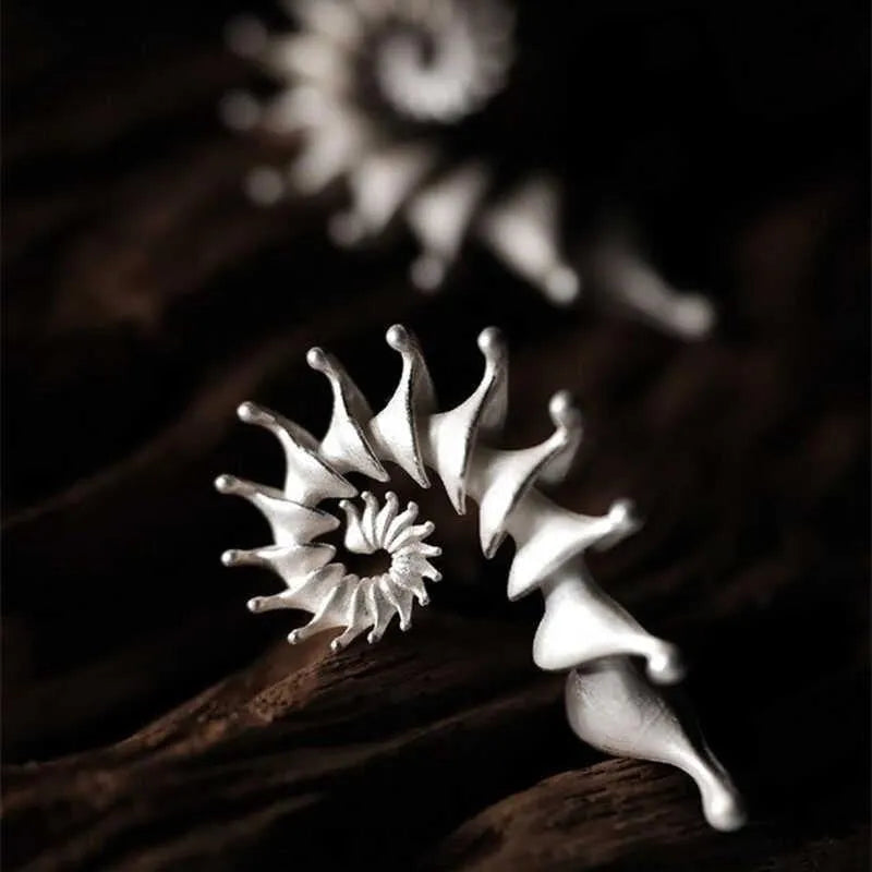 A pair of matte finish alloy conch stud earrings with a three-dimensional, irregular shape.