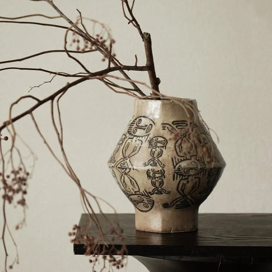 Hand-painted ceramic cylindrical vase with carved religious patterns in tribal totem flower design
