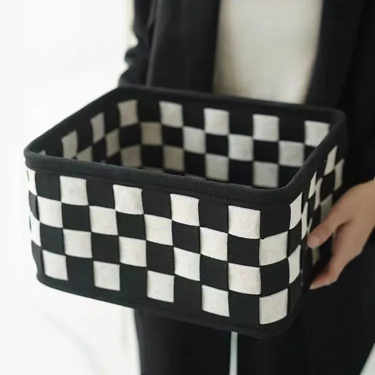 Checkerboard patterned woven felt storage basket folded flat next to it assembled