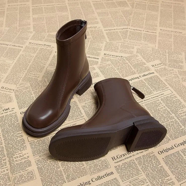 Women's black ankle boots with a thick flat heel, round toe, and back zip fastening.