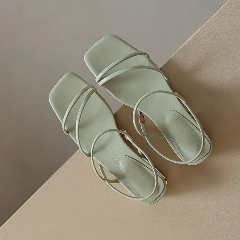 Women's green flat Roman sandals with square toe and microfiber straps on a white background.