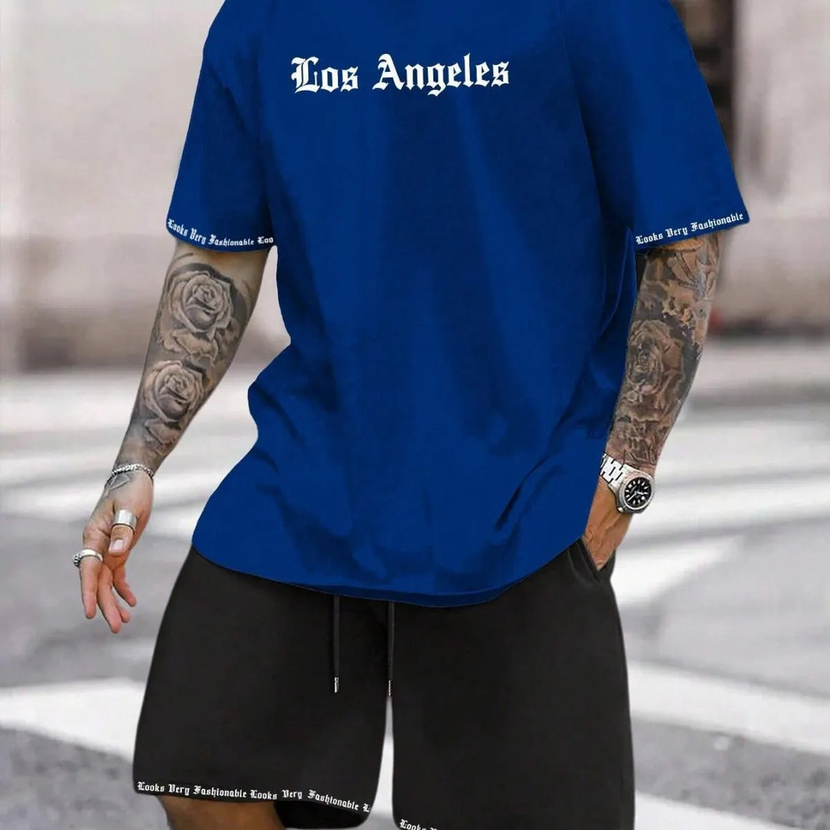 Mens blue sports style short sleeve top and shorts two-piece set on a plain background.