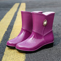 Women's purple PVC rain boot with non-slip sole and middle tube height.