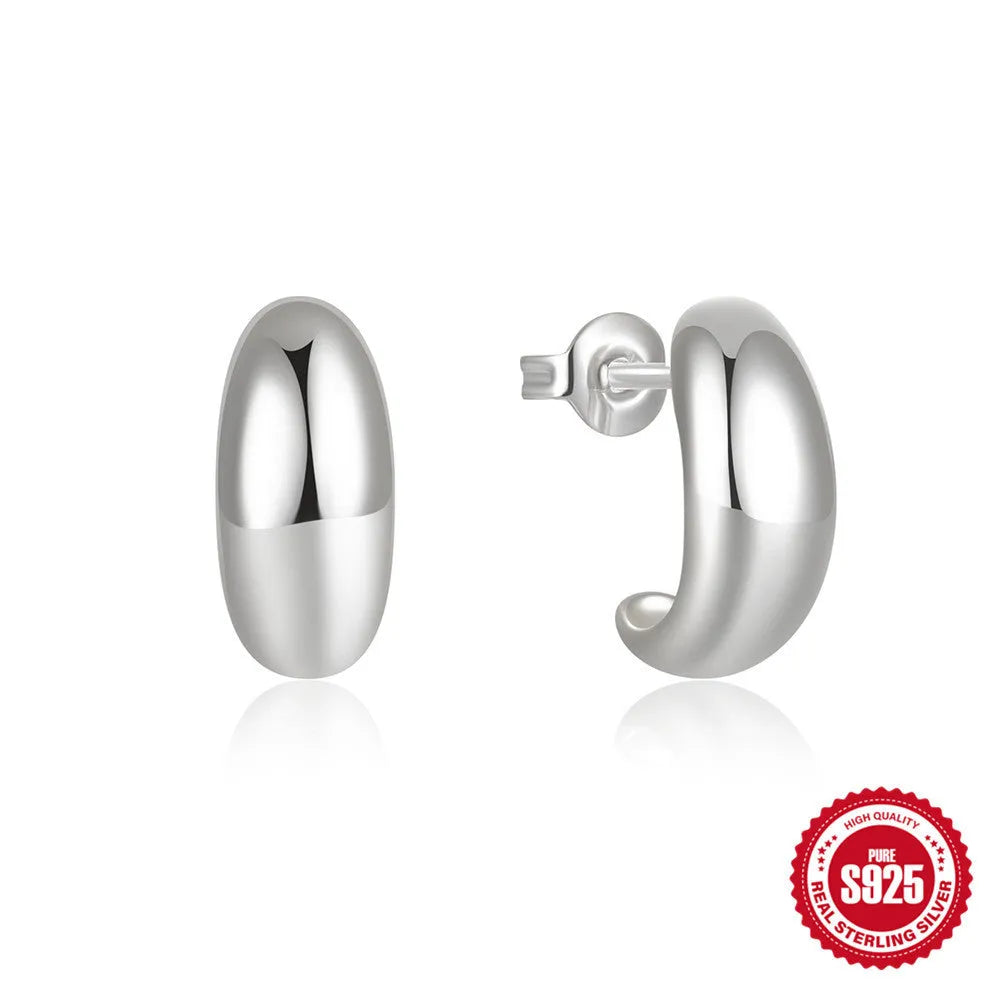 A pair of glossy C-shaped stud earrings in sterling silver, shown in both gold and white gold electroplated finishes.