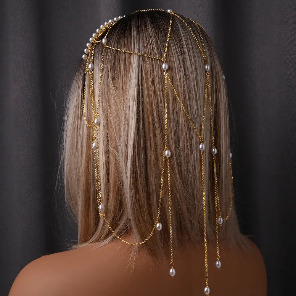 Women's gold and pearl mesh tassel hair chain fashion accessory on white background.