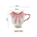 Cute white ceramic mug with a black heart bow design and printed handle ornament.