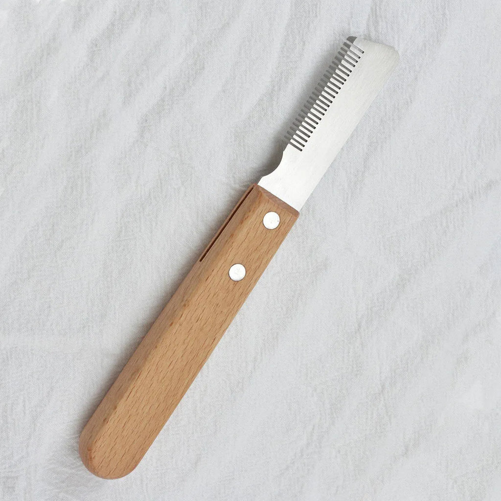 Pet stripping comb with wood handle and metal teeth for grooming cats and dogs.