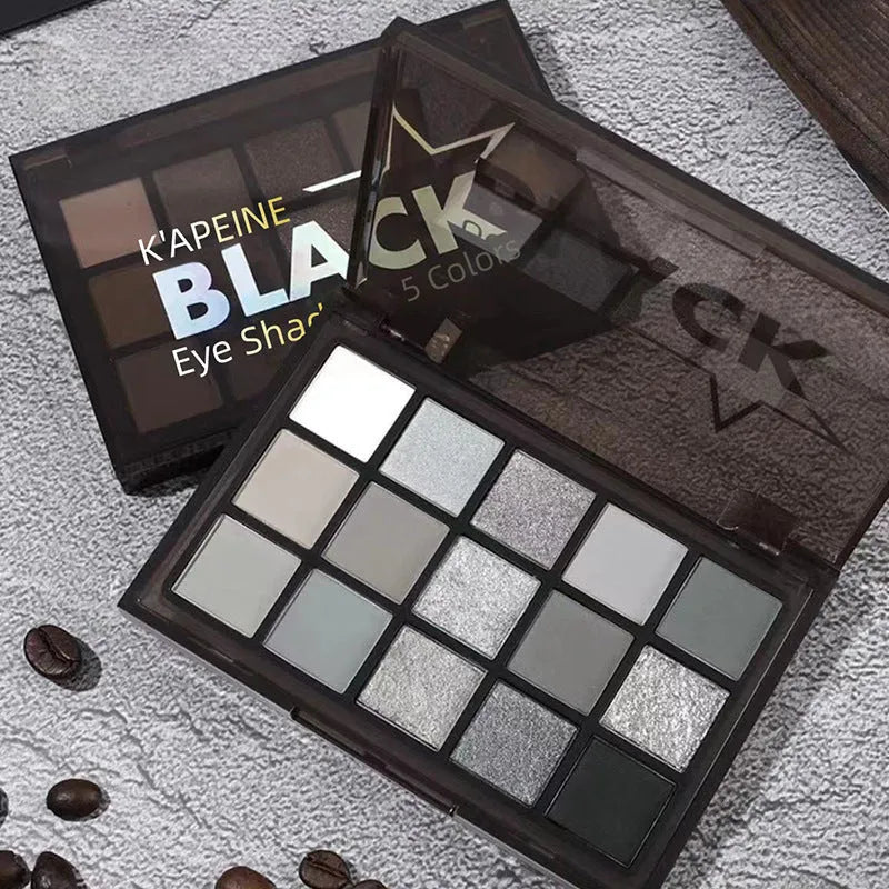 15-colour eye shadow palette showing matte and shimmer finishes in grey, black, brown and blue tones