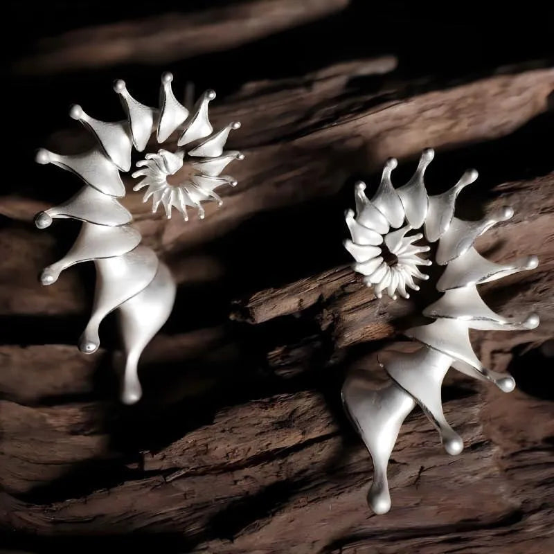 A pair of matte finish alloy conch stud earrings with a three-dimensional, irregular shape.