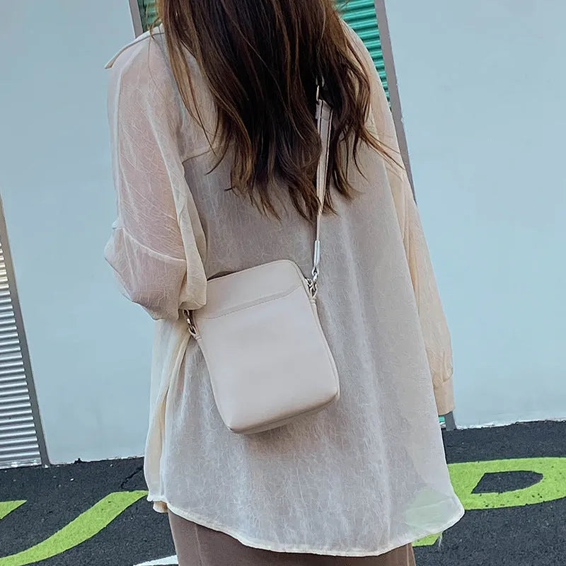 Solid colour PU leather mobile phone crossbody bag showing compact size and shoulder strap.
