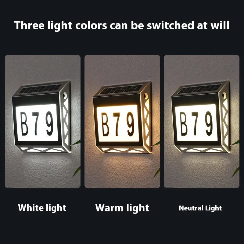 Black solar-powered outdoor doorplate light with digital LED number display mounted on a wall