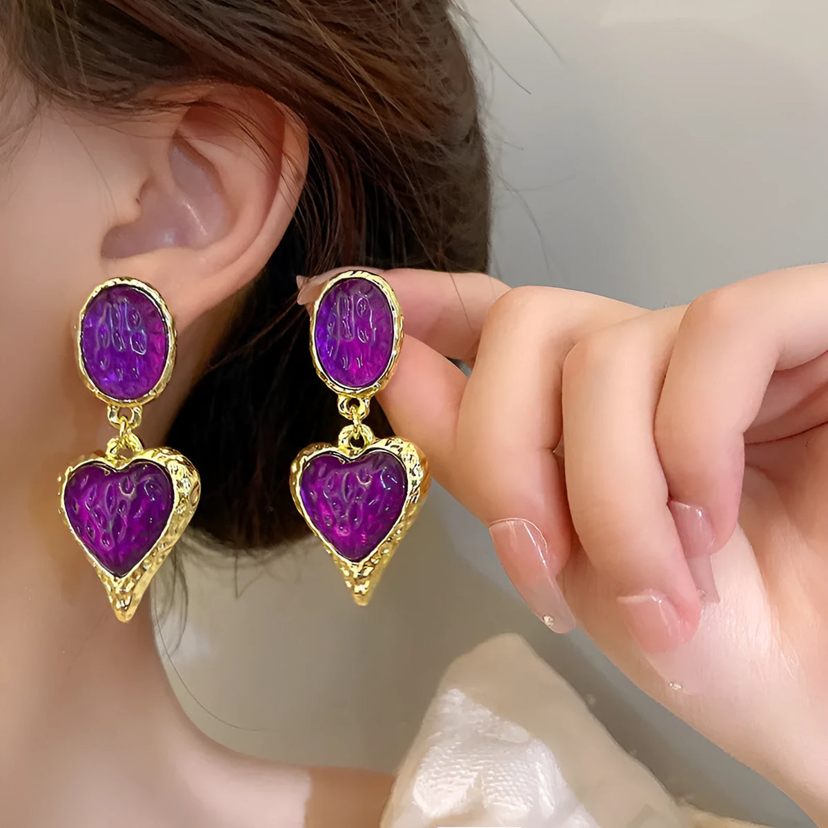 Pleated oval heart-shaped alloy stud earrings on silver posts in purple, red, green, and yellow/white colours.