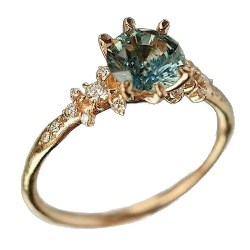 Gold geometric ring with claw-set zircon stones on chamfered square pattern