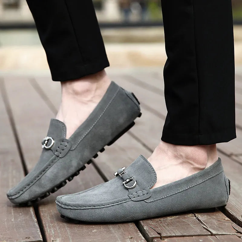 Men's black slip-on leather shoes with a square toe and matte finish on a plain background.